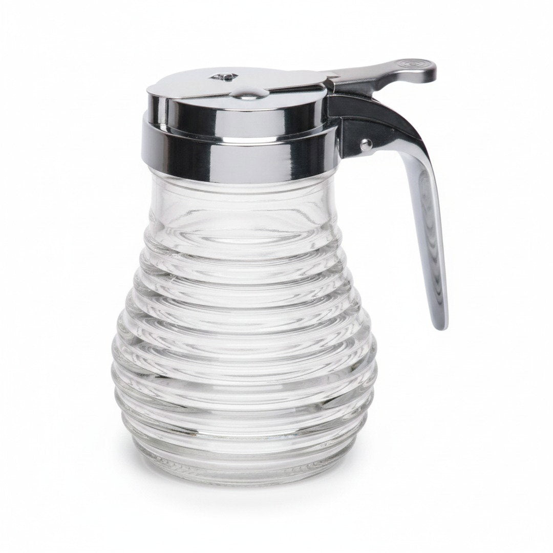 Clear glass Pancake House beehive syrup dispenser with ribbed sides, chrome lid, thumb lever, and curved handle on a white background.